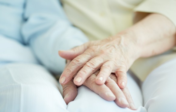 Caregiver holding hands with senior woman
