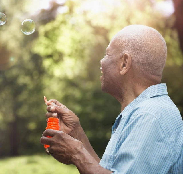 Senior man blowing bubbles