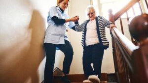 Caregiver helping resident down stairs