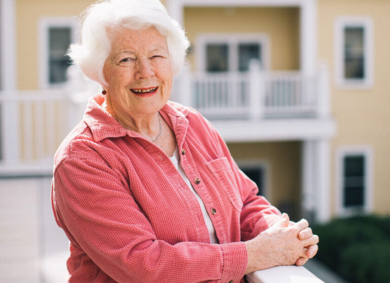 Caroline Jacobs standing upon the balcony overlooking the campus at The Commons in Lincoln.